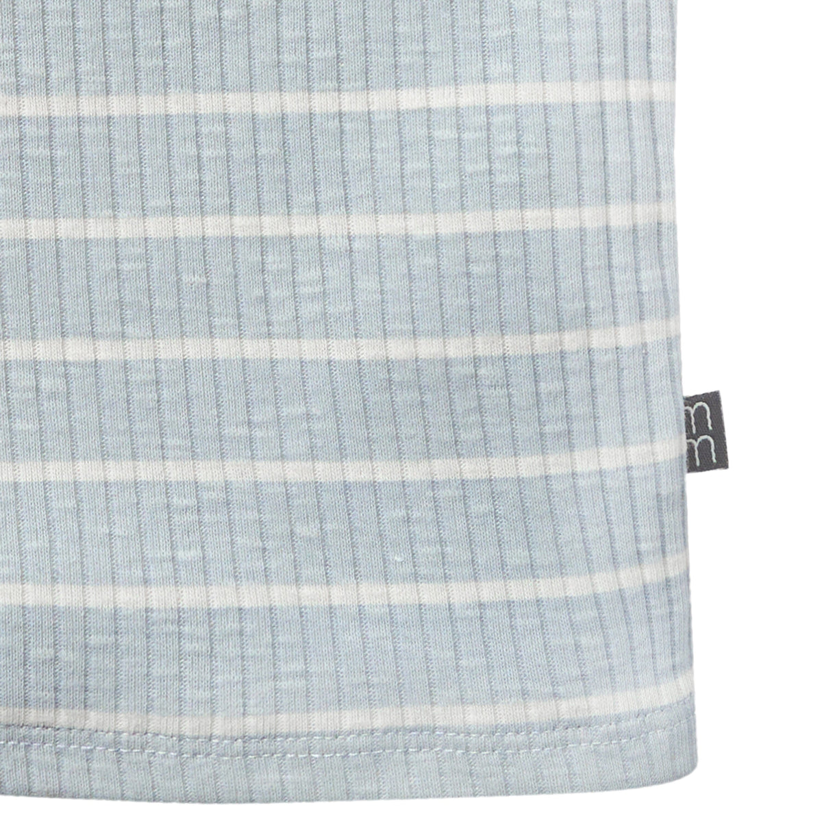 Close-up of a textured fabric with horizontal stripes and a brand tag on a white background