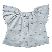 Light blue blouse with floral pattern and ruffled shoulders on a white background
