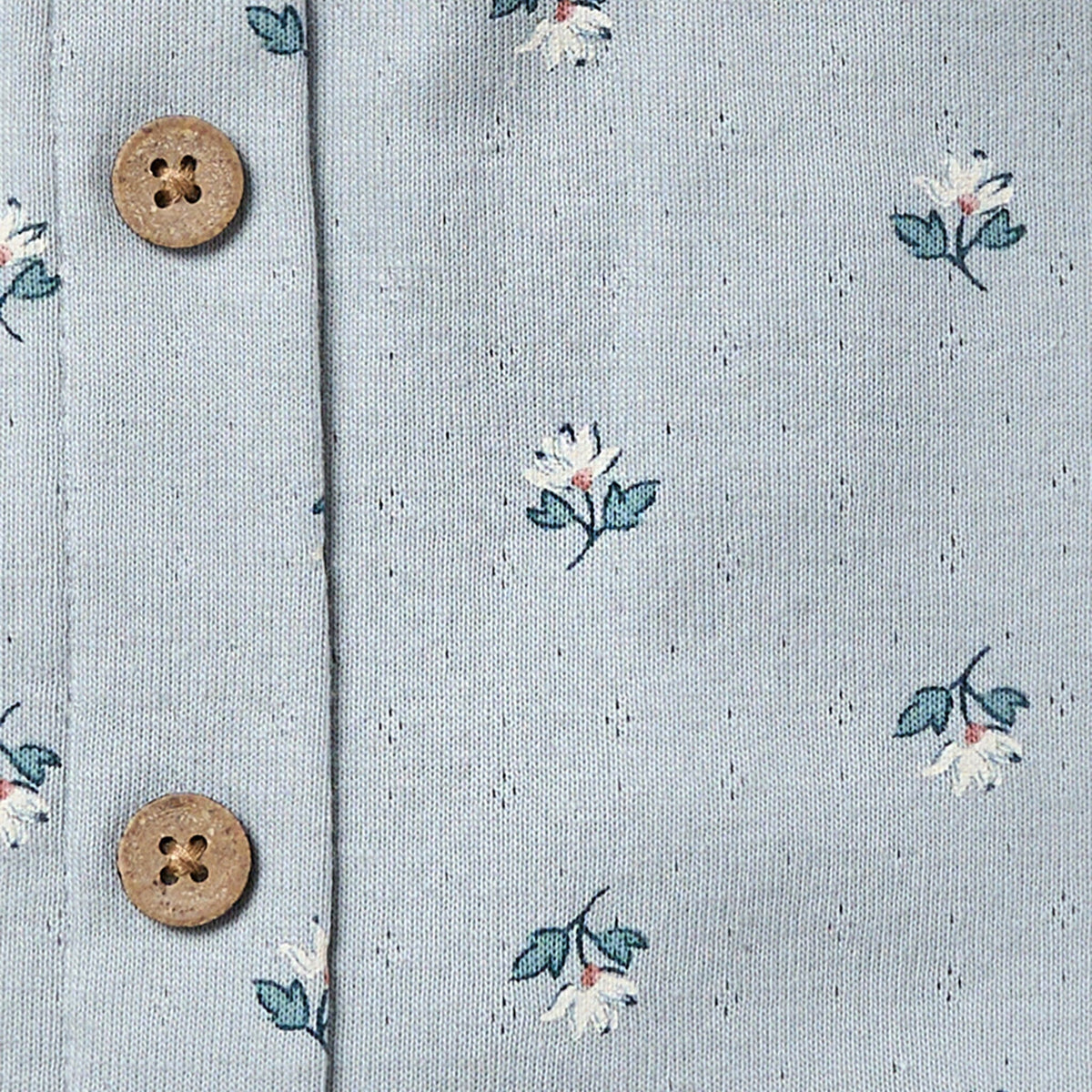 Floral patterned fabric with two wooden buttons on a light blue background