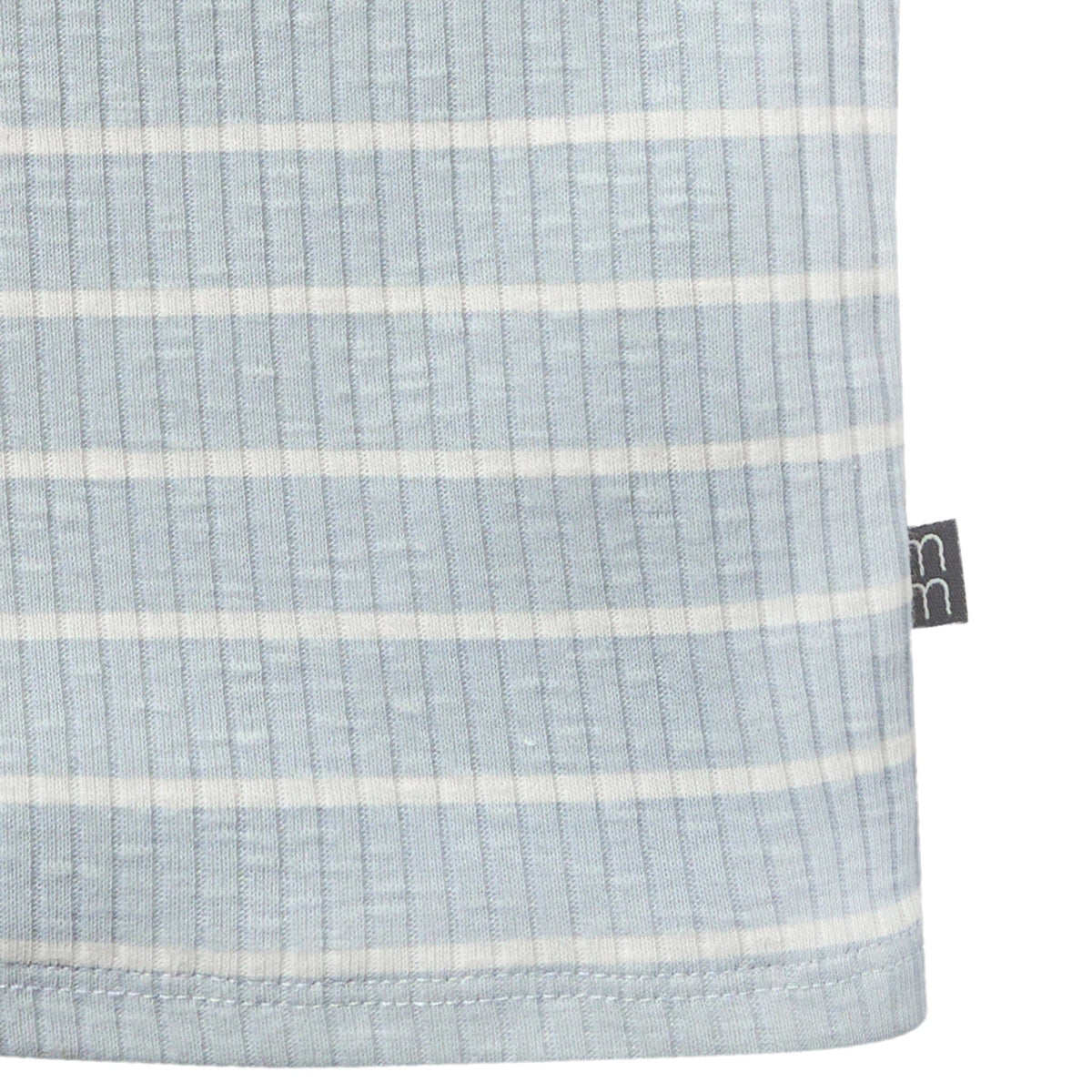 Close-up of a light blue fabric with white stripes and a brand tag on a white background