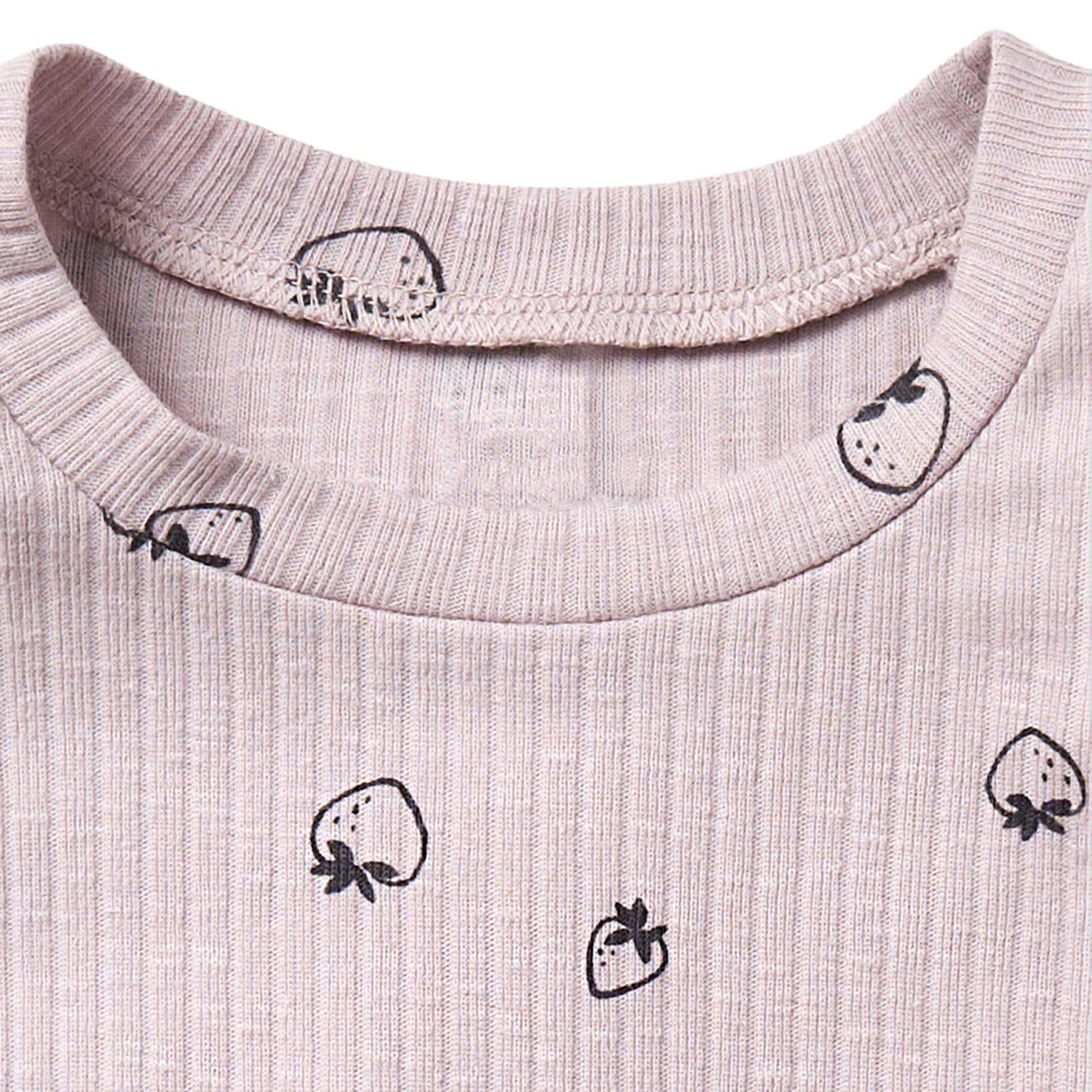Close-up of a light pink fabric with black strawberry prints on a white background